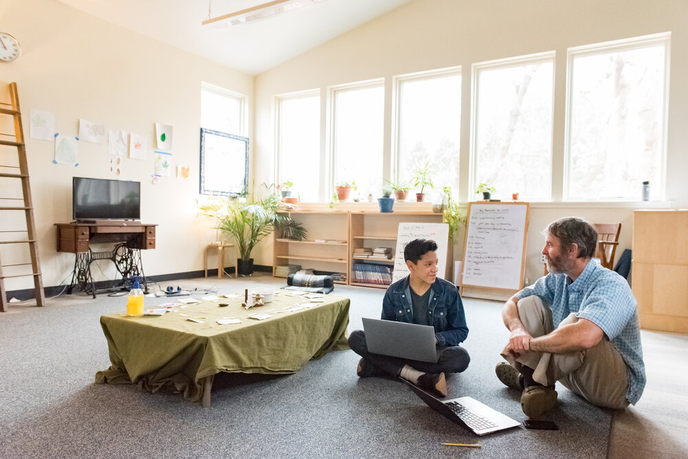 A Montessori Middle School students works with a teacher. 
