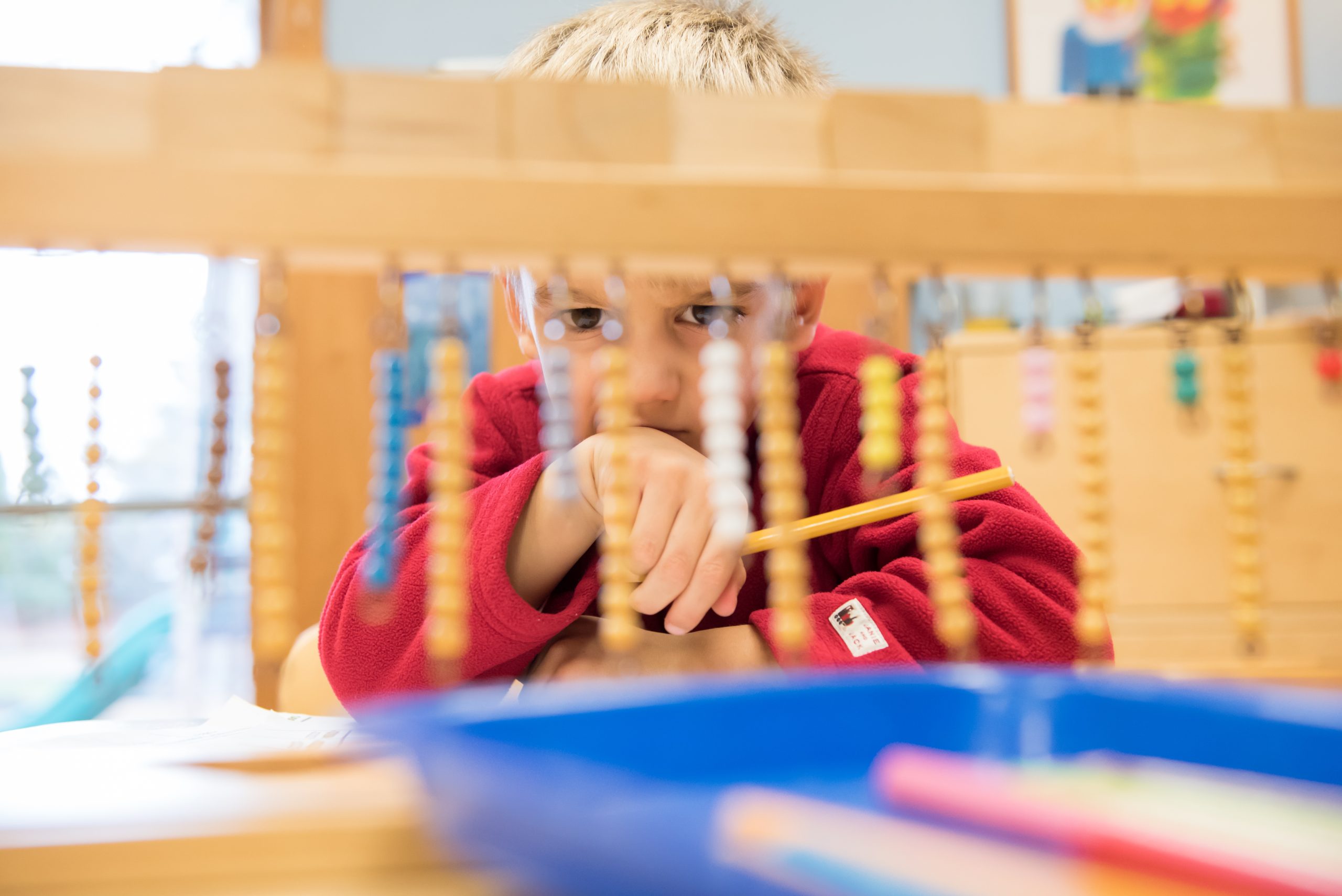 A Montessori Children's House student works on a math lesson