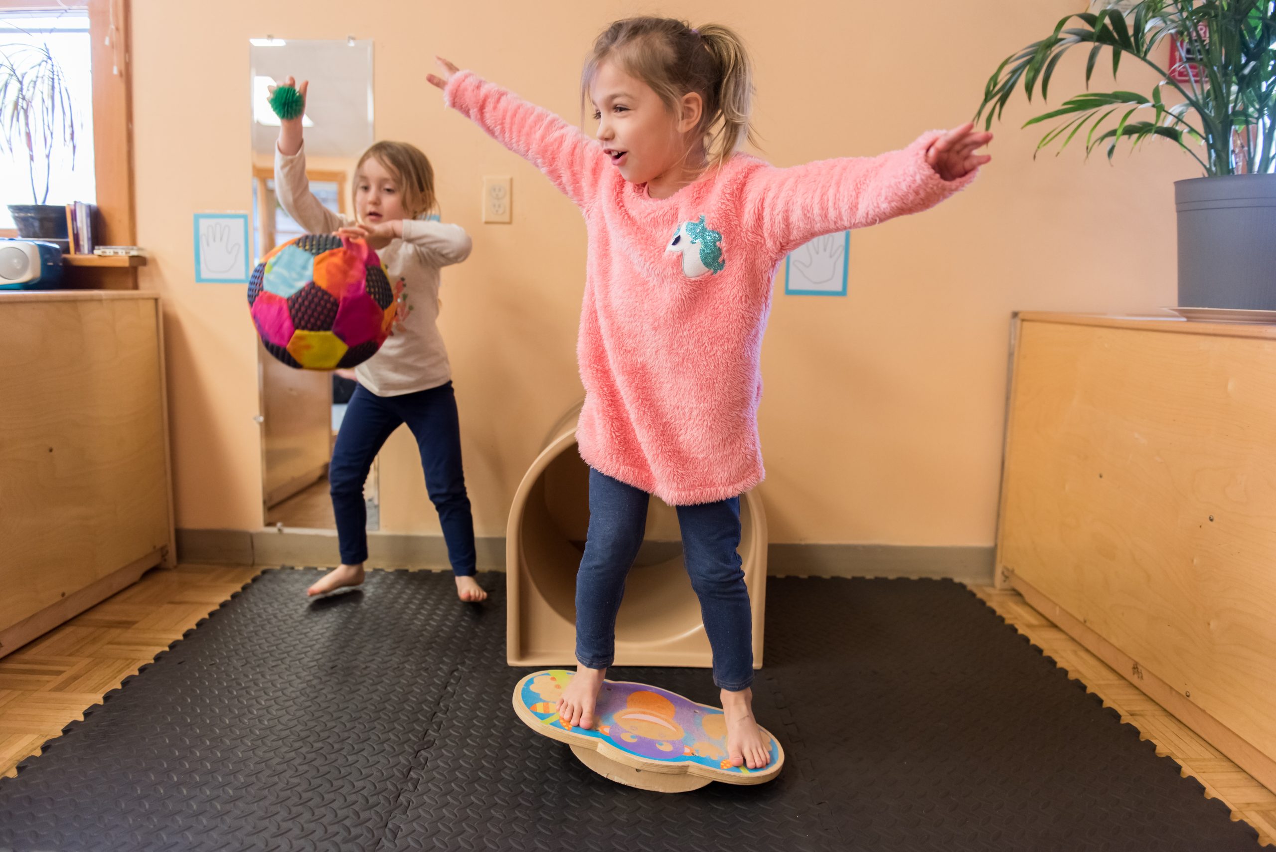Two Montessori Children's House students enjoy some free movement activities in the classroom