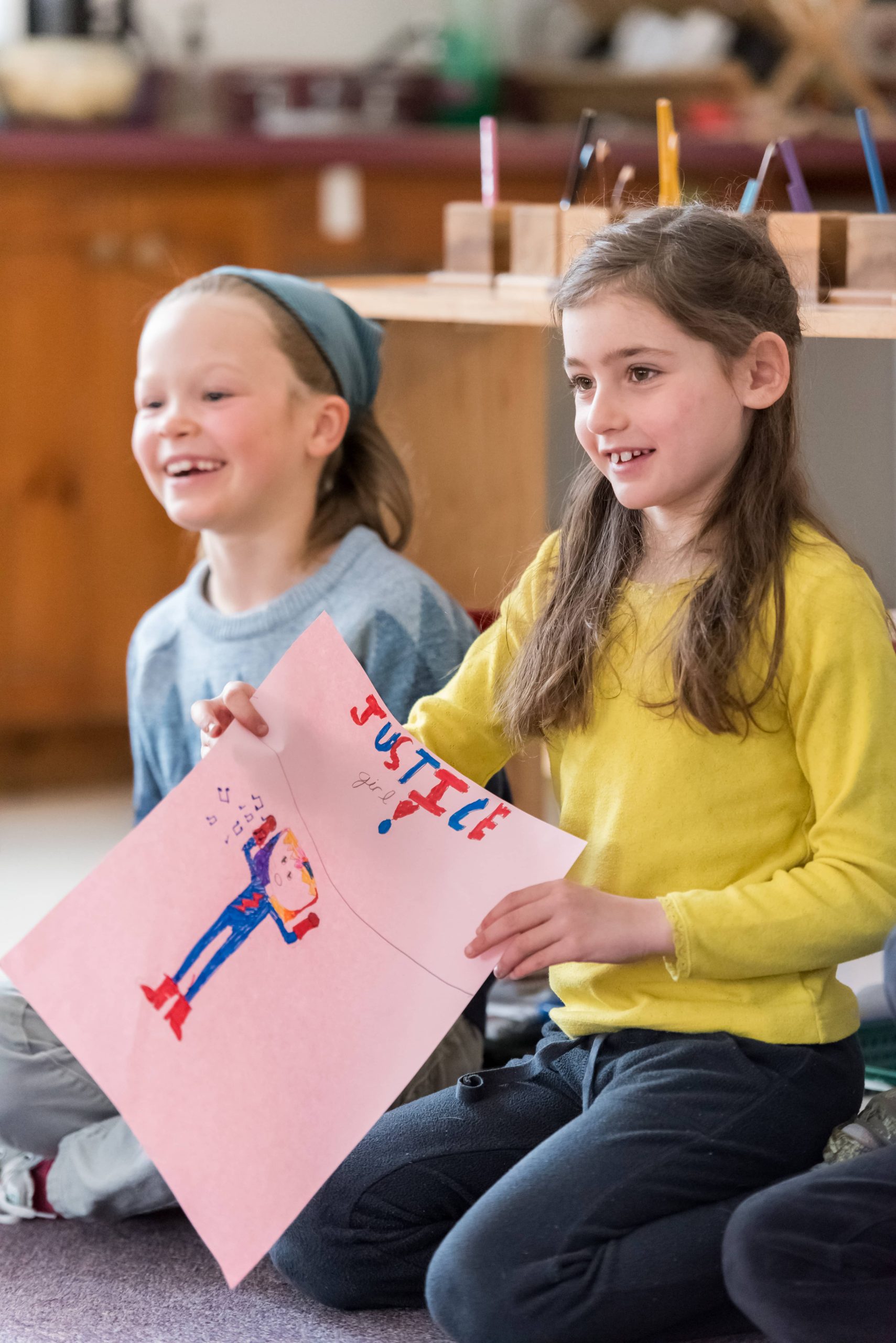Two Montessori Lower El students show off an art project centered on Social Justice
