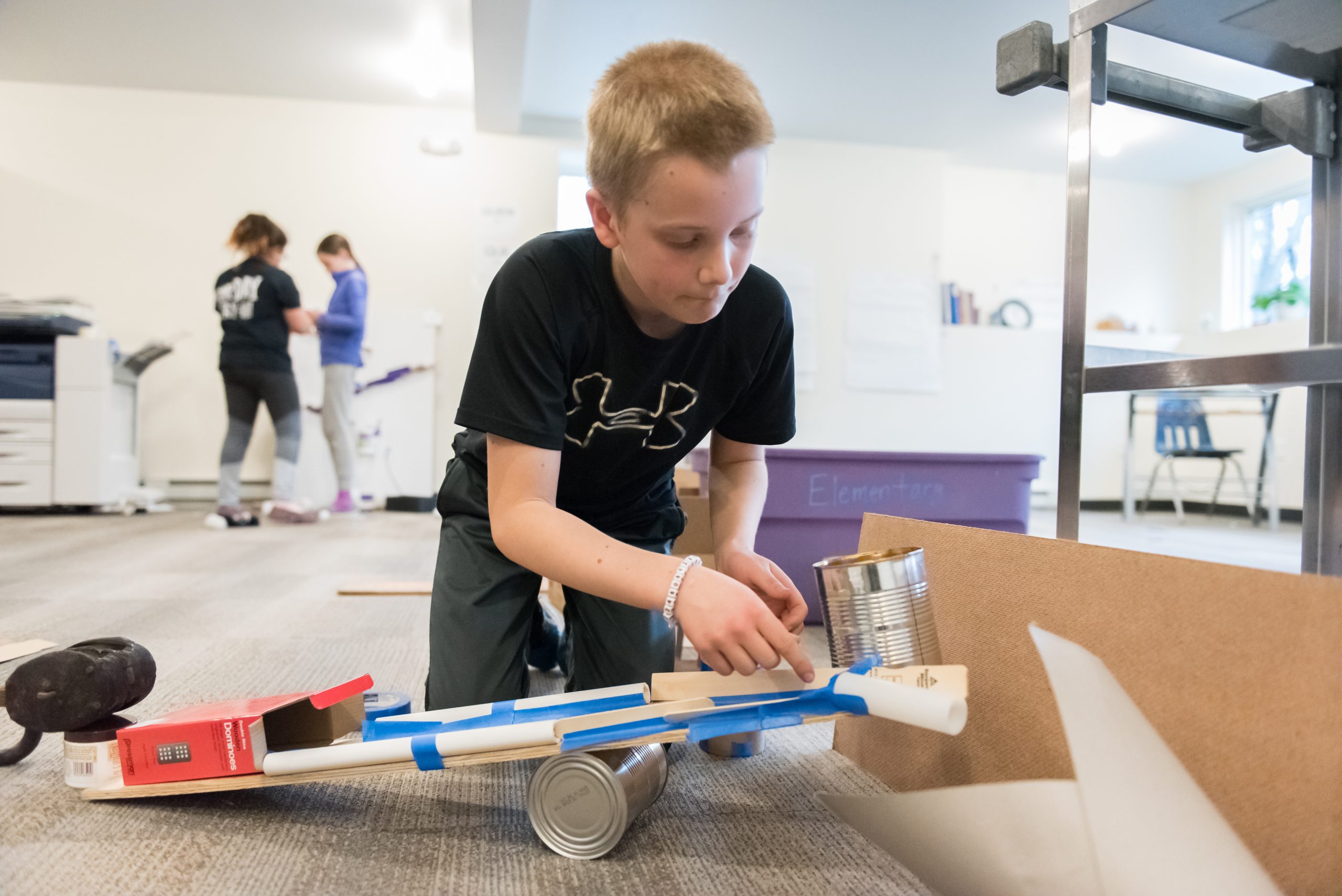 A Montessori Upper El student works on a science project