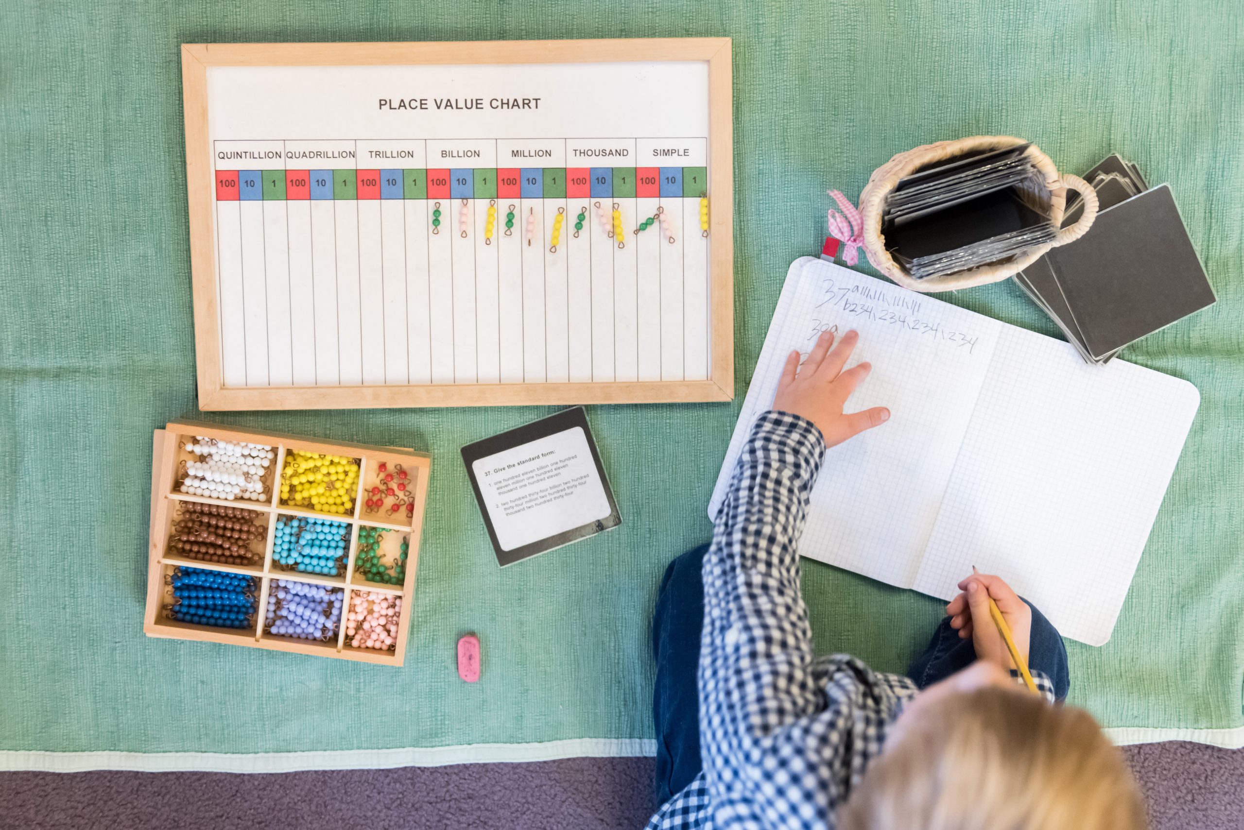 A Montessori Lower El students works on a math lesson