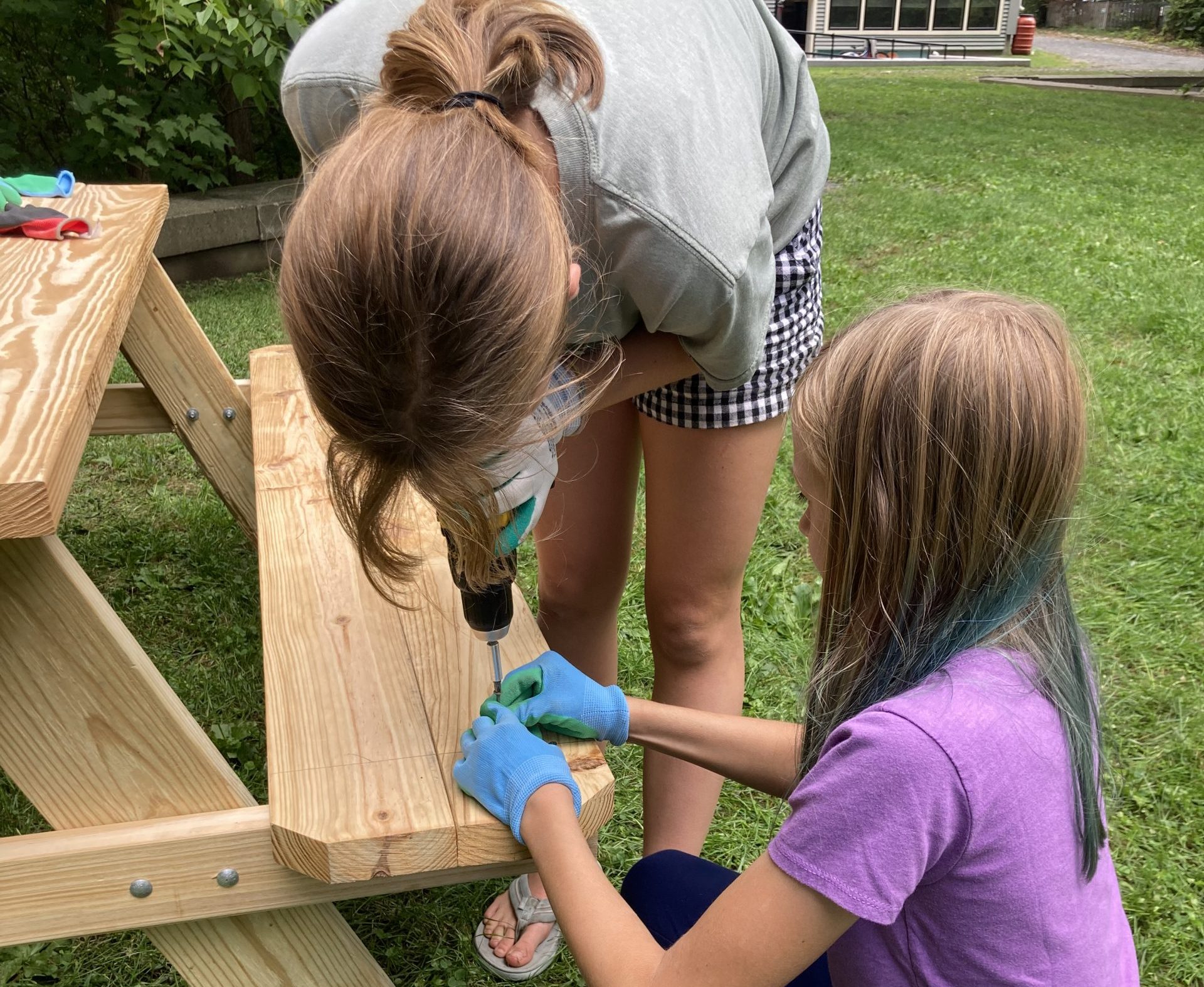 Two Montessori Middle School students work on assembling a picnic table