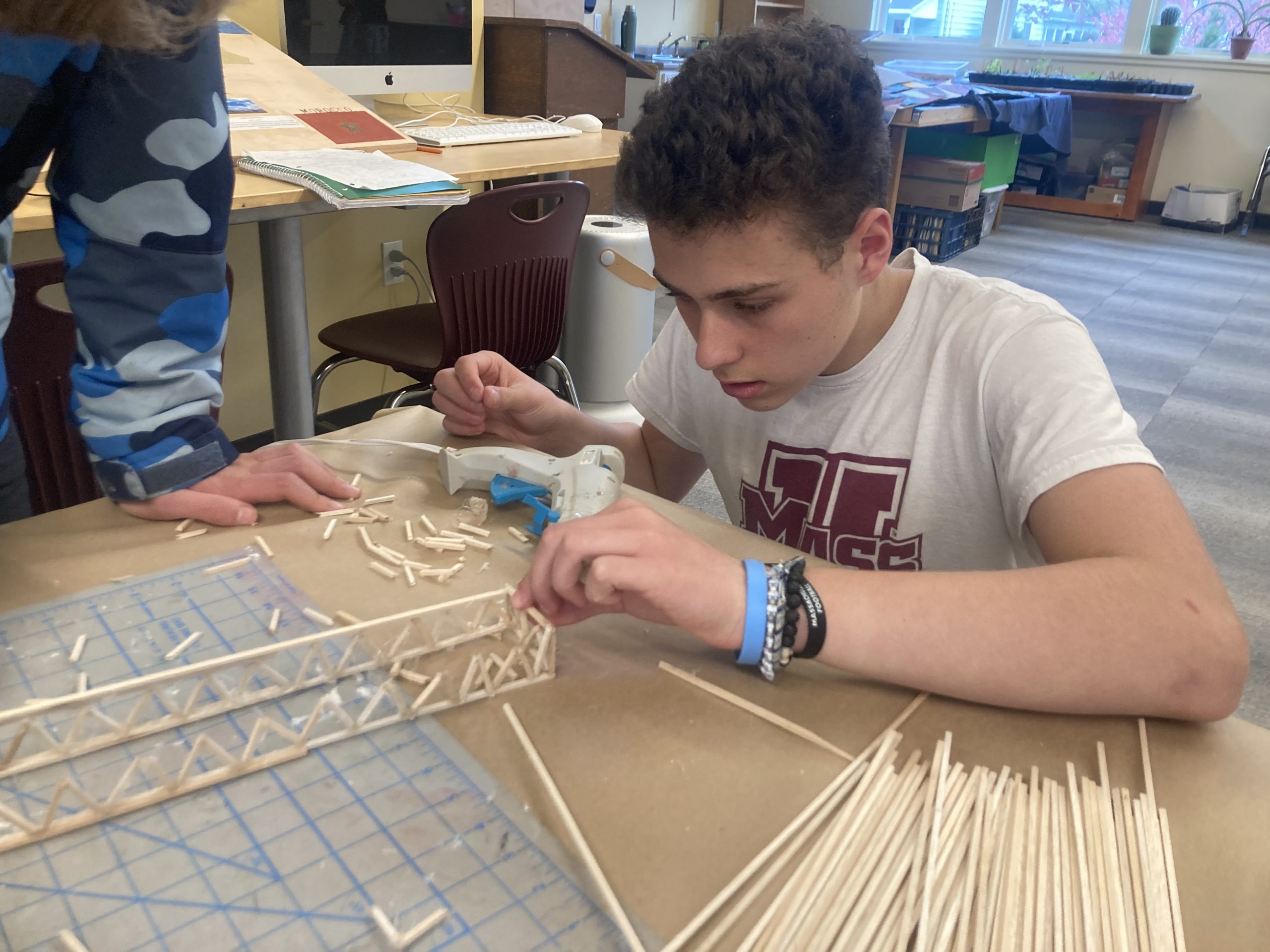 A Montessori Middle School student works on wooden model