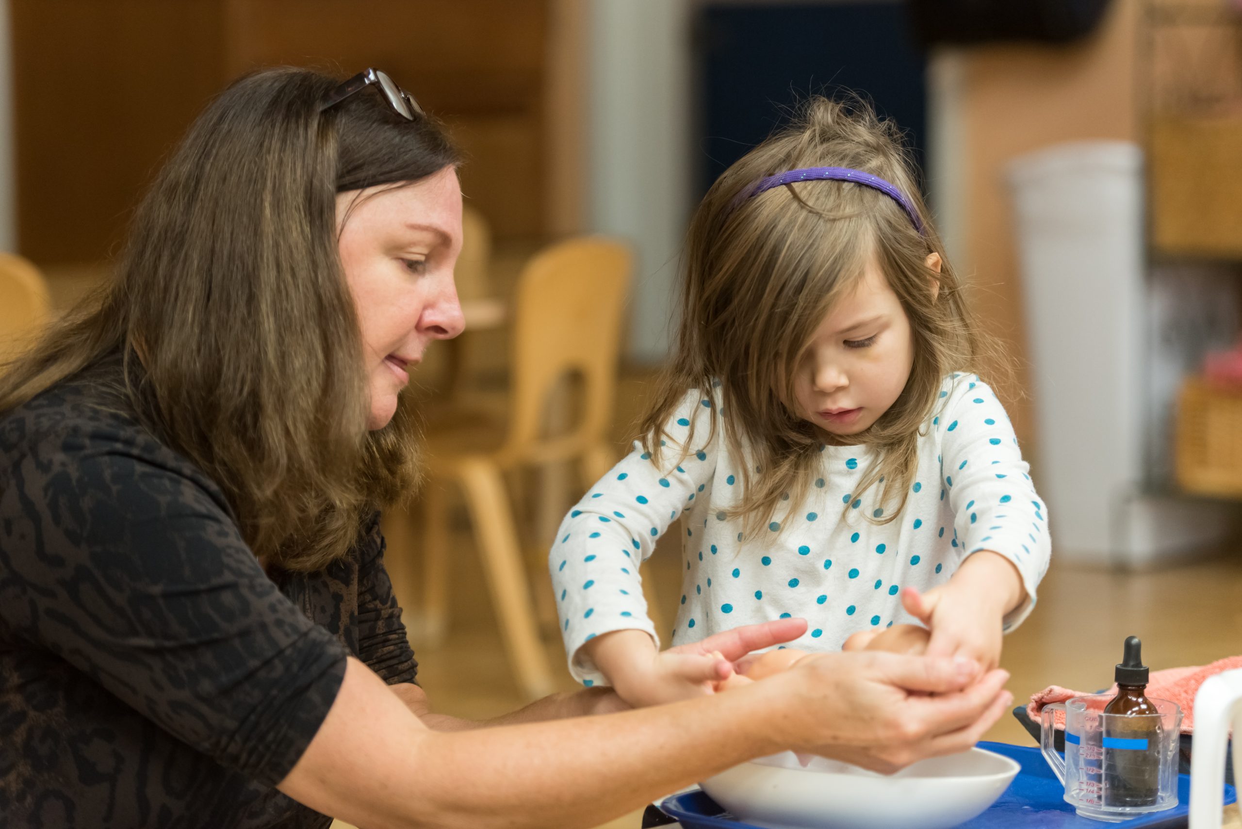 A Children's House teacher works with a student