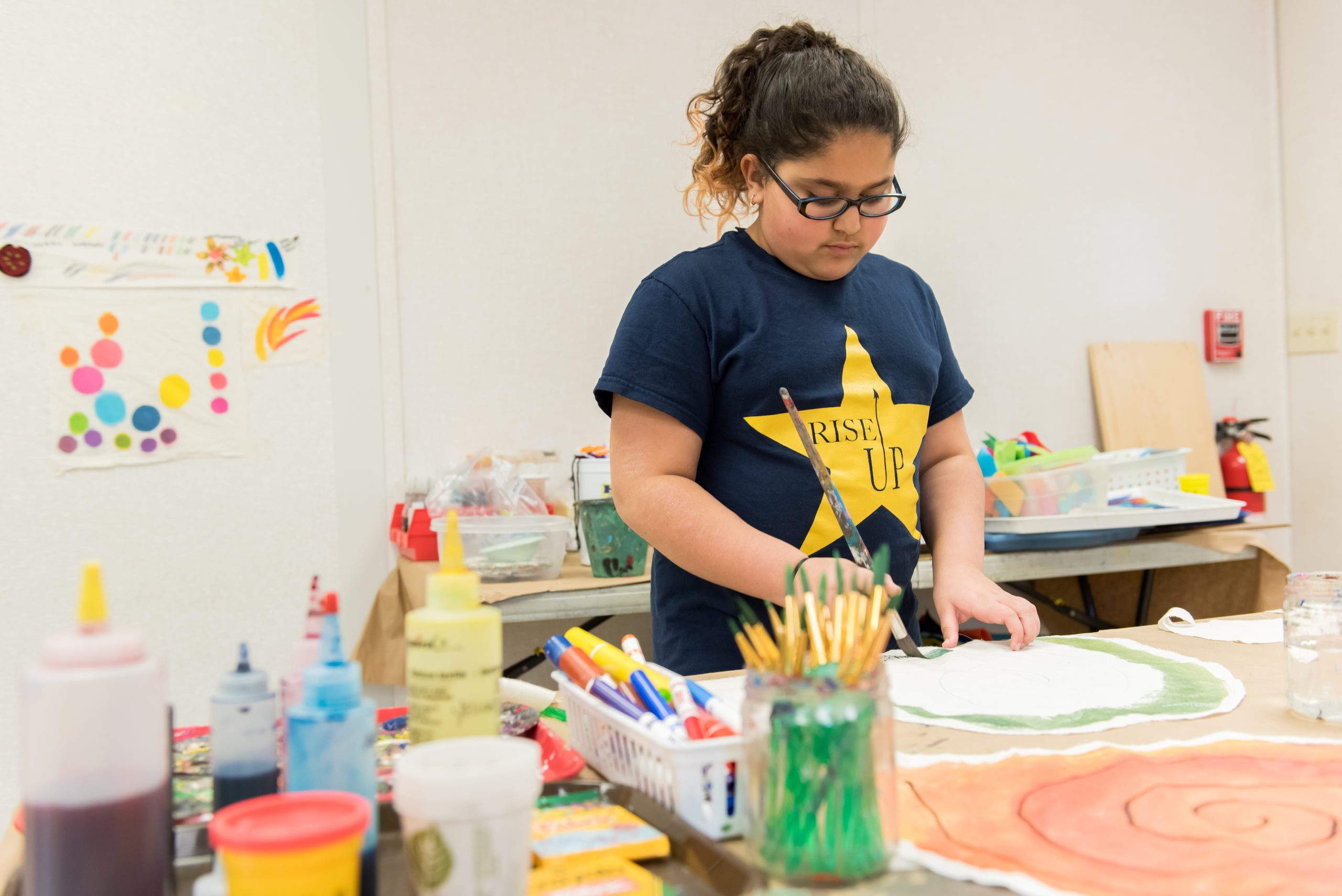A Montessori students works on a painting project