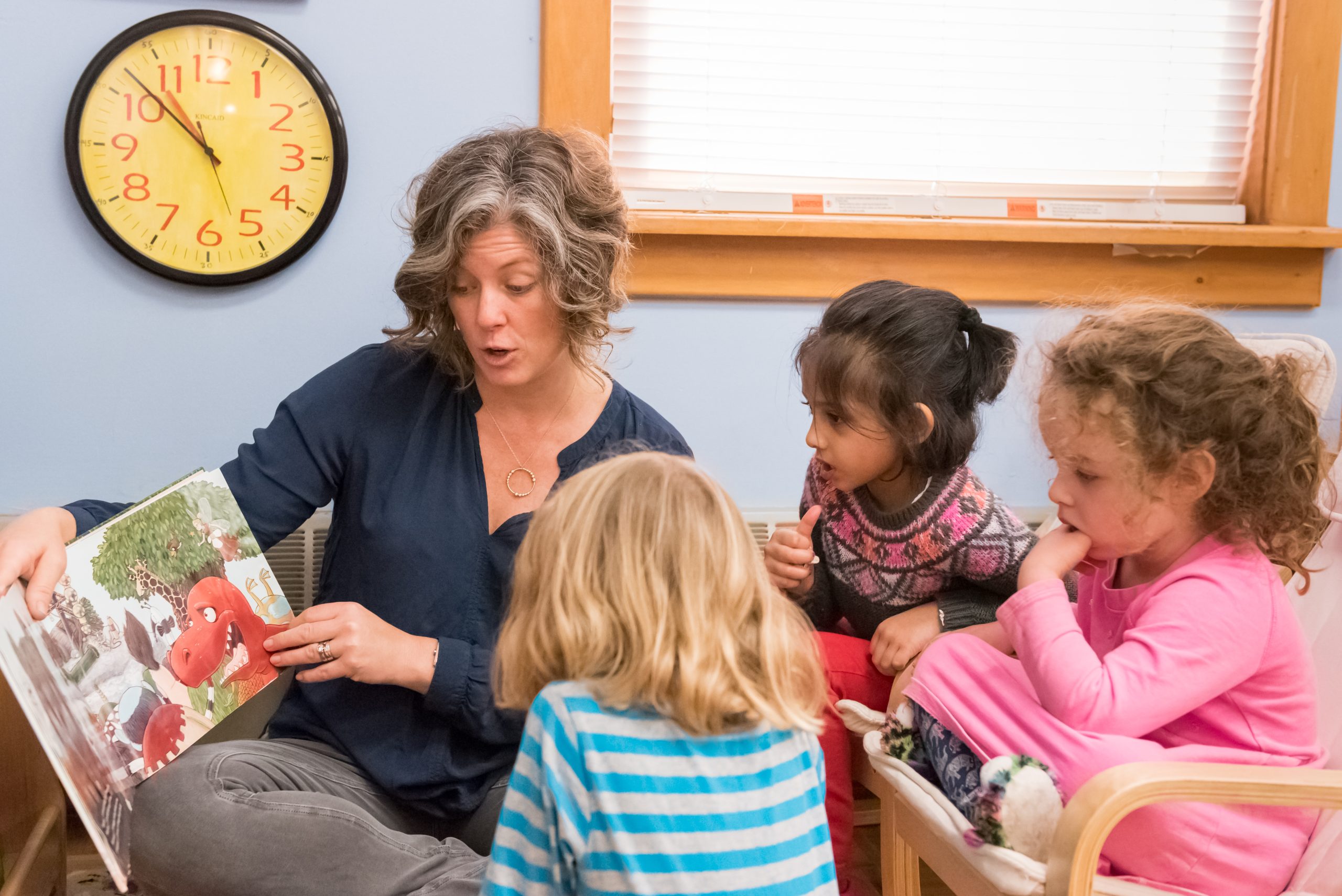 A teacher works with a group of Children's House students